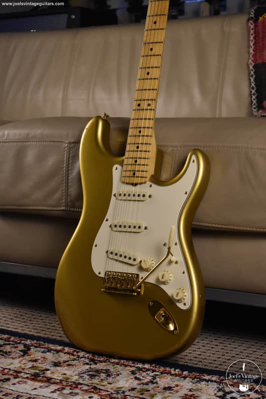 Yellow electric guitar in red velvet case, showing fretboard and pickups.