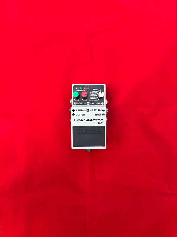 White and black electronic line selector pedal with knobs and switches.