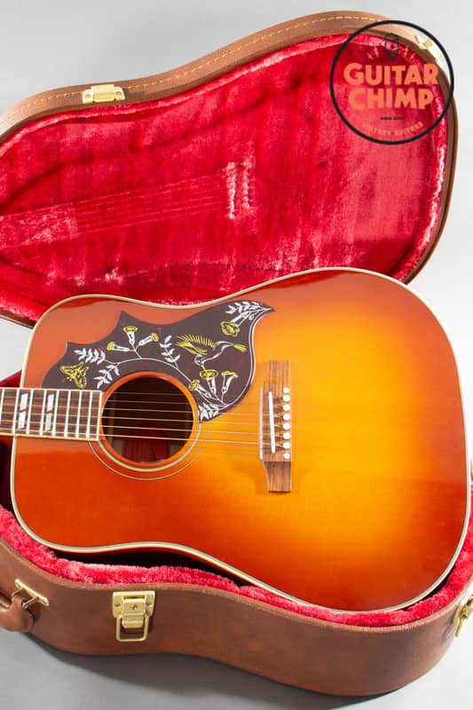 Acoustic guitar in amber finish with black case and strap.