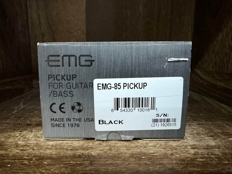 Black EMG guitar pickup box, rectangular, simple design.
