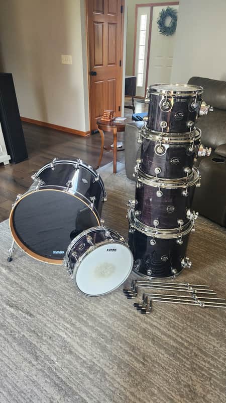 Stacked dark grey marching snare drums with black hardware.