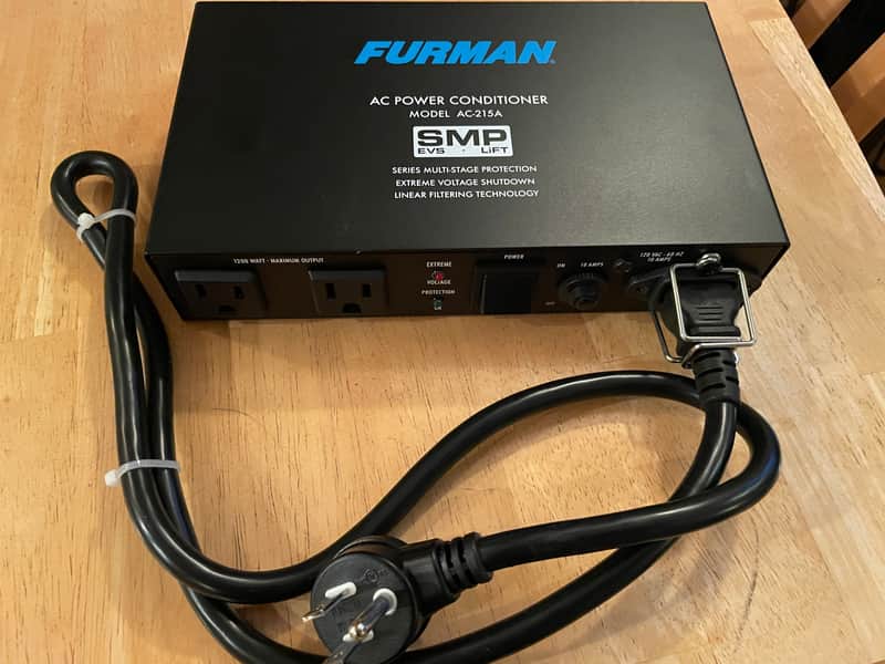 Black Furman AC power conditioner with attached black power cord.