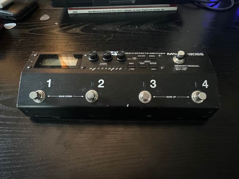 Black multi-effects switcher pedal with digital display and knobs.