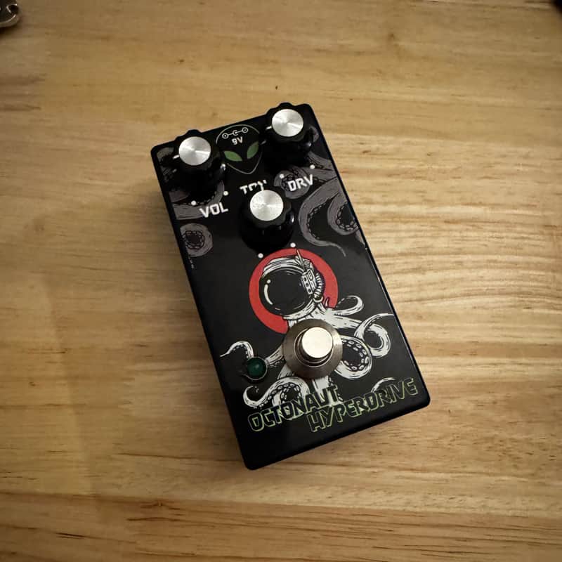 Black and green electronic device with octopus logo on a brown surface.