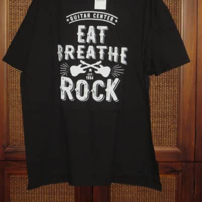 new in package A+ Guitar Center EAT BREATHE, ROCK Men's Size X-Large (XL), Black 100% Cotton Short Sleeve T-Shirt - Graphic is in White and it says / shows: GUITAR CENTER EST. 1964, EAT, BREATHE, ROCK + has dual guitars, stars, lines (Style # GC005-11730) image 1