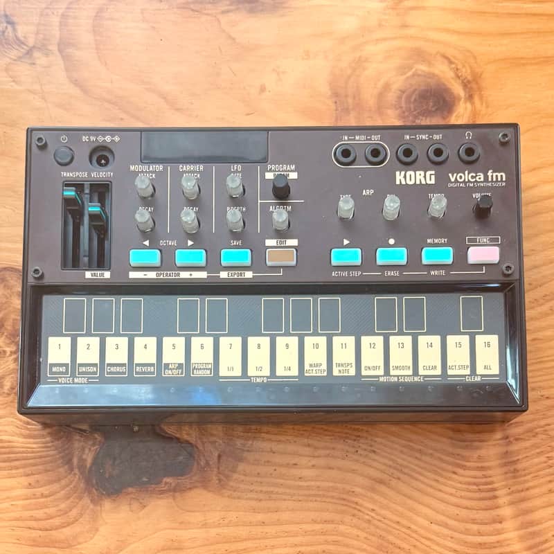 Black synthesizer with red digital display and numerous knobs and pads.
