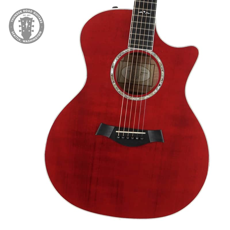 Orange and black Taylor acoustic guitar in velvet-lined case.