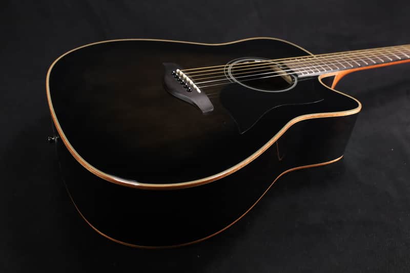 Black acoustic guitar with sunburst finish, visible soundhole and bridge.