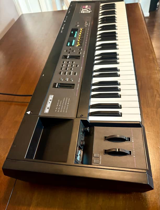 Black keyboard synthesizer with white and black keys. Electronic instrument.