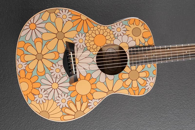 Acoustic guitar, natural wood finish, shown against a dark background.
