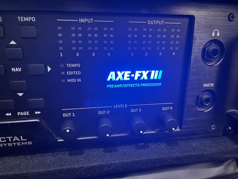 Black rack-mounted audio unit and black cassette case on a wooden surface.