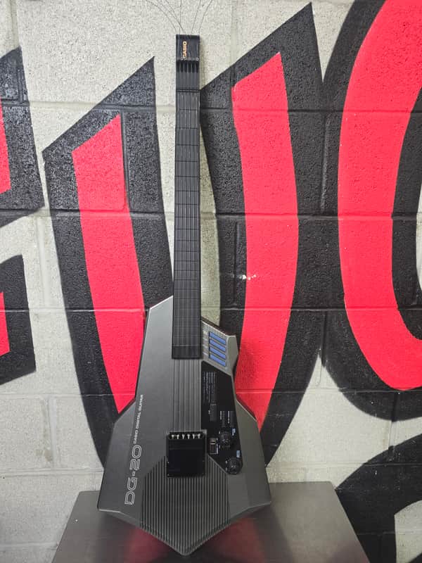 Silver Casio Digital Guitar DG-20 with black controls and strap.