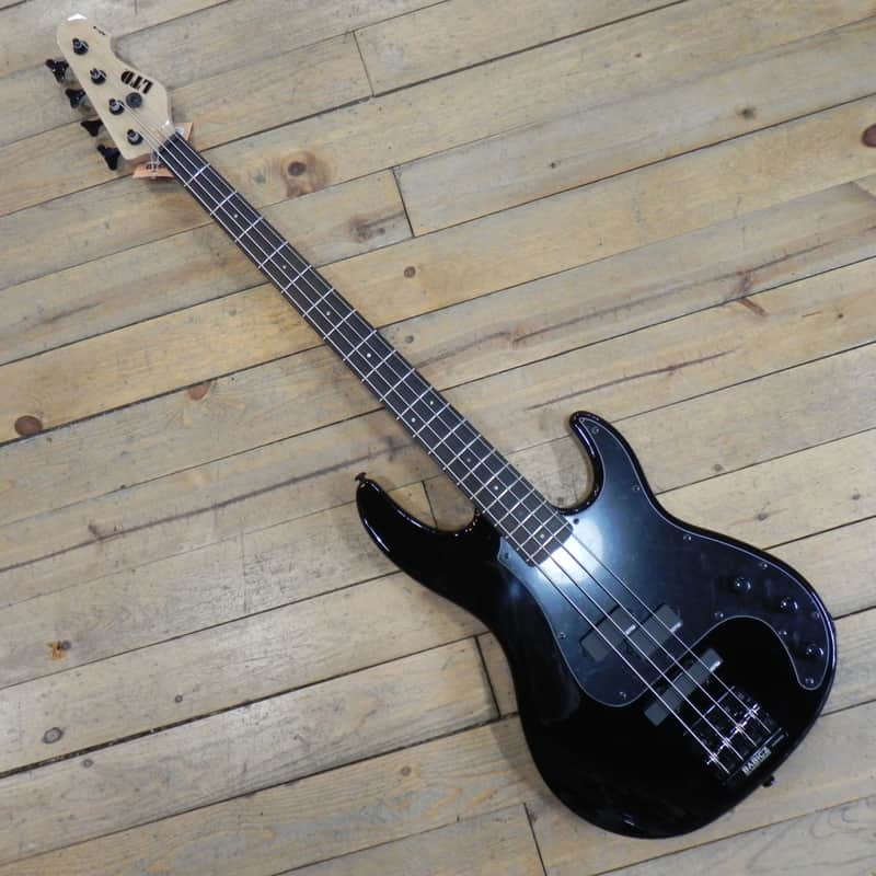 Light blue electric guitar with black pickguard, resting on patterned surface.