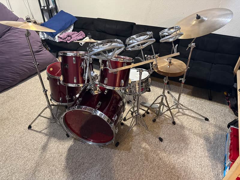 Yellow and chrome drum set with black bass drum, displayed on a surface.