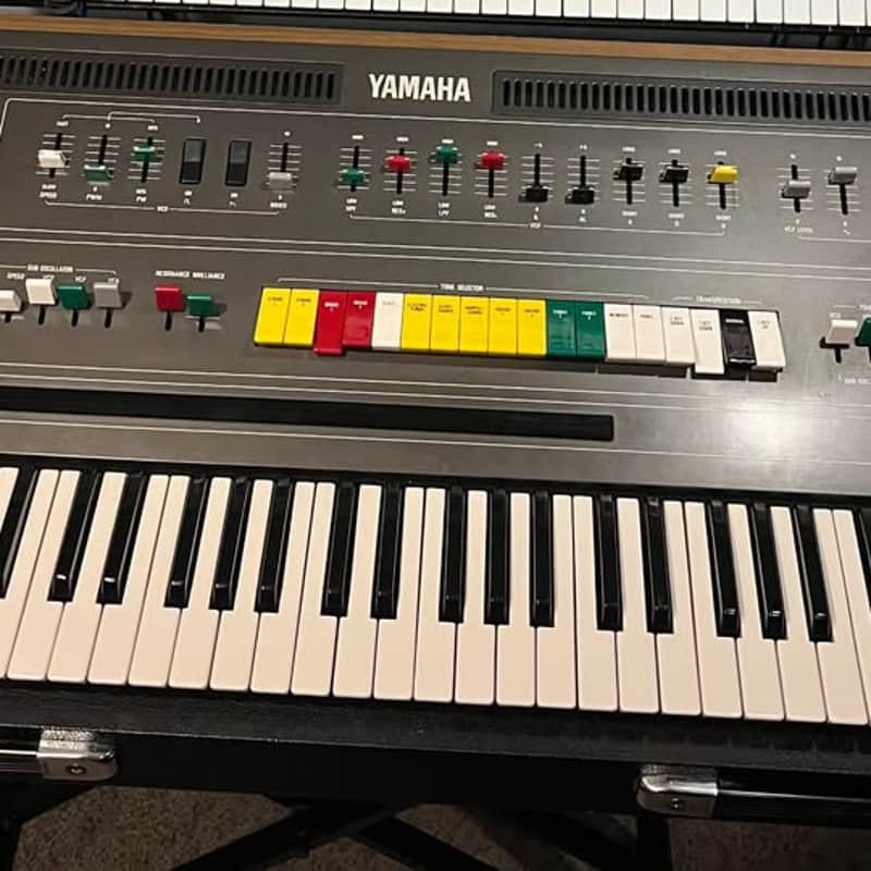 Black Yamaha synthesizer keyboard with multiple knobs and white keys.