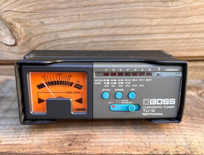 Black and silver Boss chromatic tuner with digital display and tuning needle.