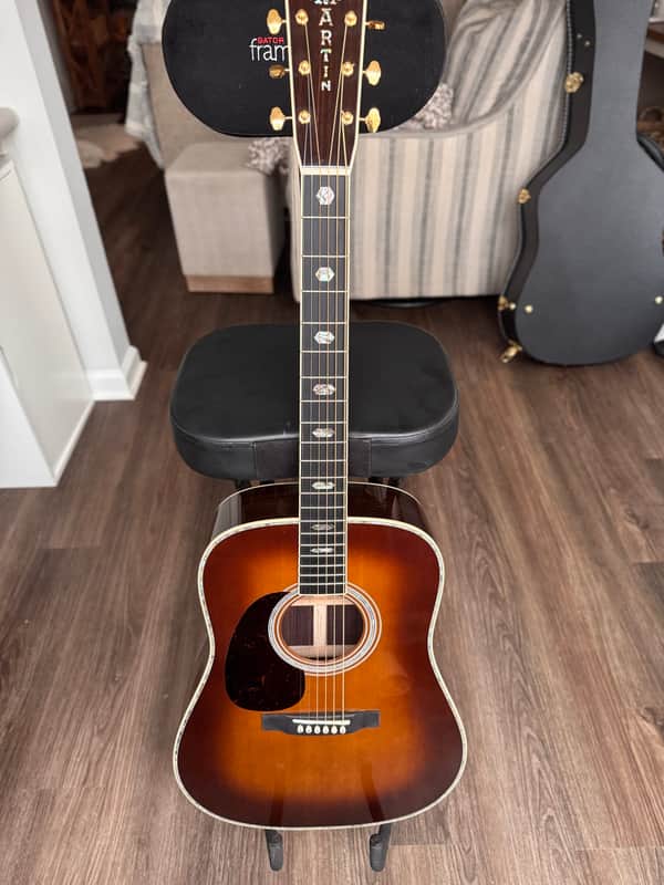 Acoustic guitar in a green velvet presentation case, visible soundhole and fretboard.