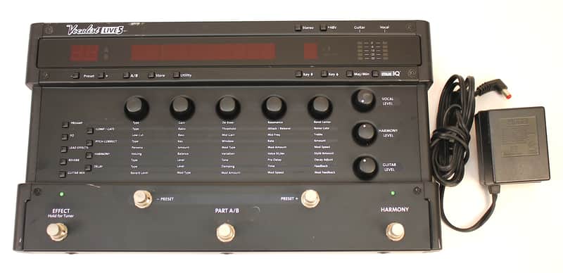 Black audio effects pedalboard with knobs and switches inside a protective case.