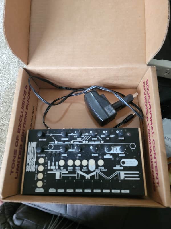 Black and white electronic music equipment in open white box.