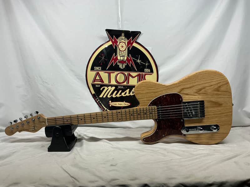 Light wood electric guitar in black velvet-lined case.