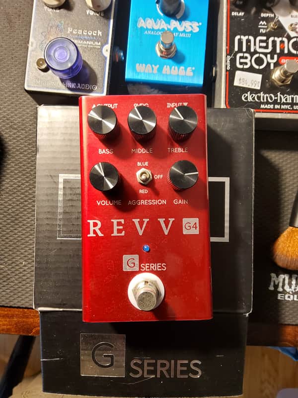 Black REVV amplifier box next to red REVV G4 amplifier.