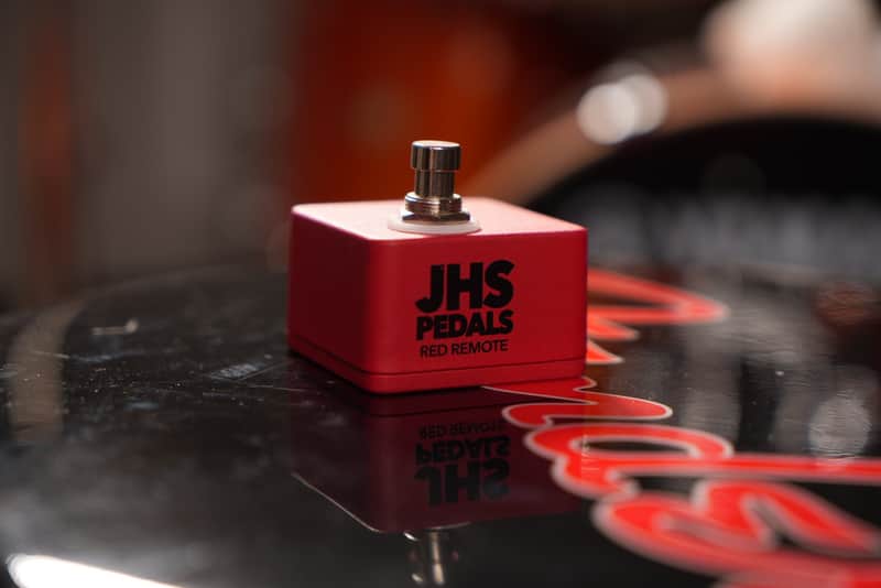 Red JHS Pedals Red Remote footswitch on wooden surface.