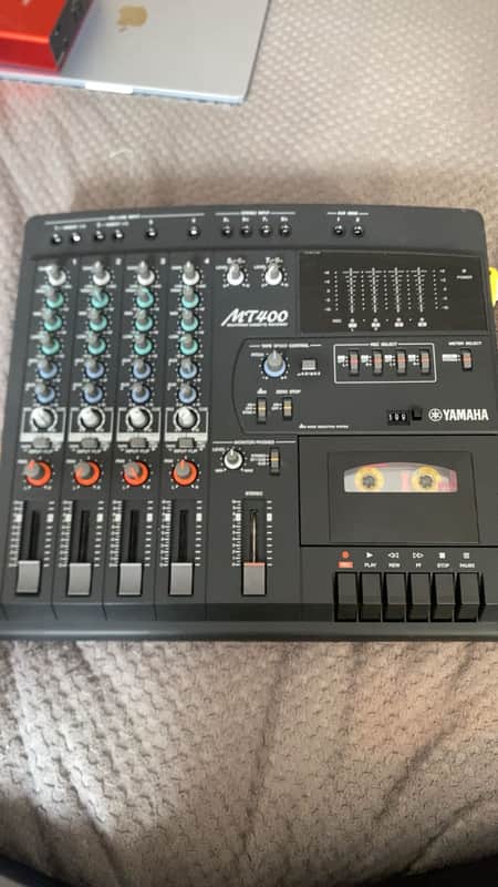 Black Yamaha MT400 mixing console with numerous knobs and faders.