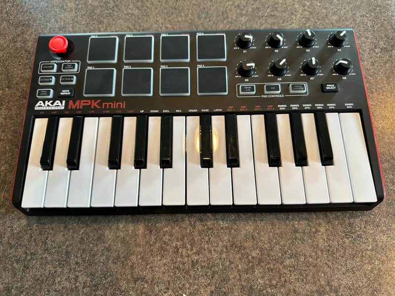 Akai MPK mini keyboard controller, silver and black, in original box.
