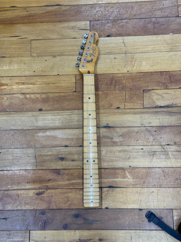 Fender Telecaster fretboard, light wood, visible frets and neck.