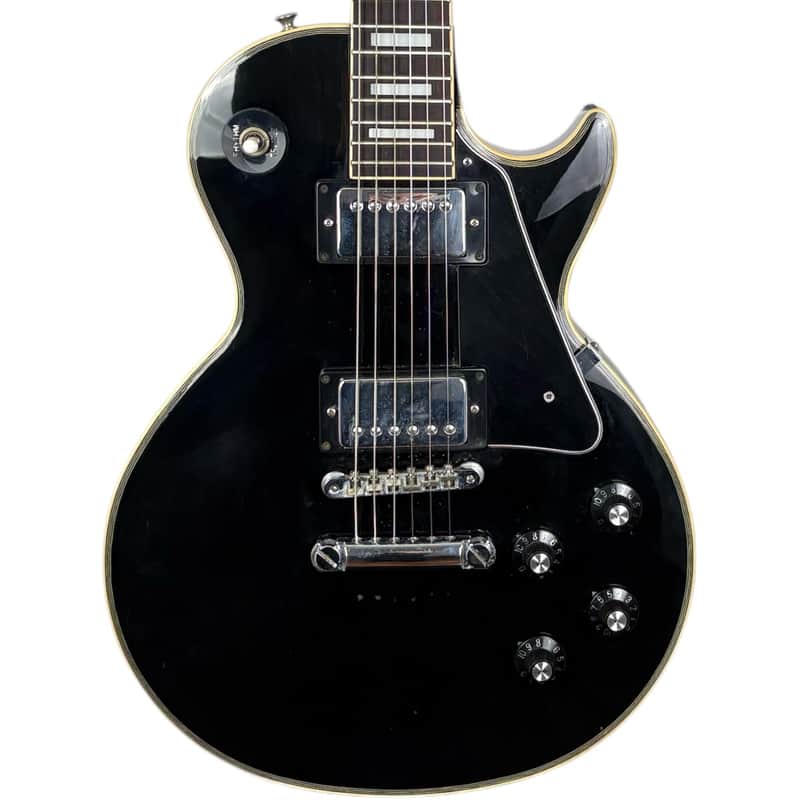 Brown electric guitar with gold pickguard and chrome hardware.