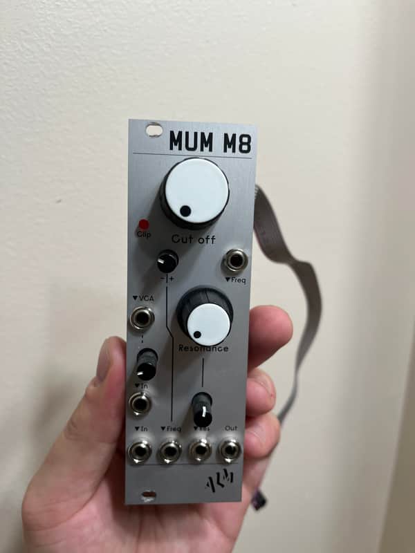 White electronic module with black knobs and jacks, labeled "MUM M8.