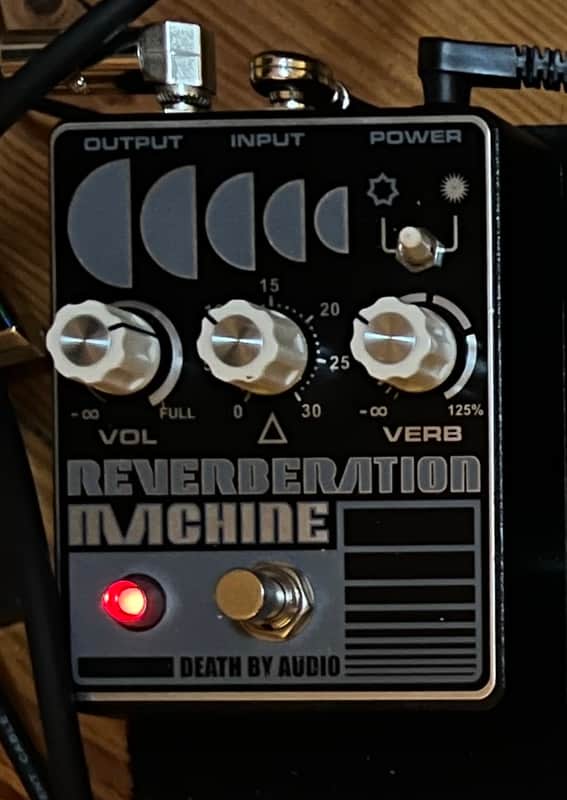 Black and silver reverb machine pedal with knobs and input/output jacks.
