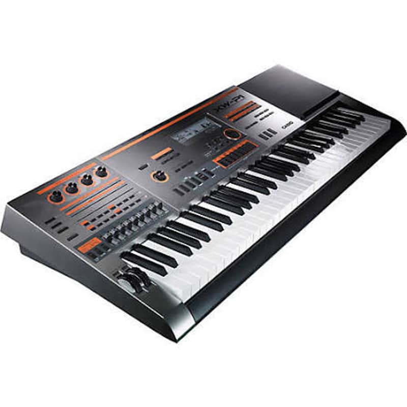 White and gray electronic keyboard with orange accents, displayed next to black spheres.