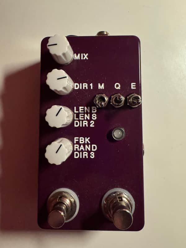 Blue guitar effects pedal with knobs and jacks, showing various controls.