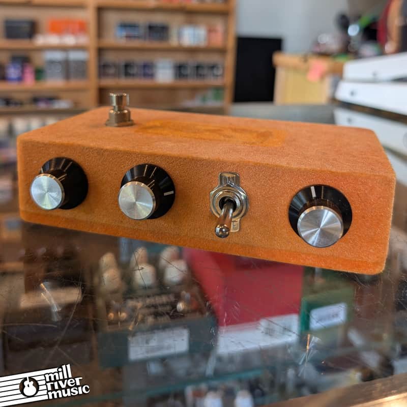 Orange guitar effects pedal in box with instruction sheet.