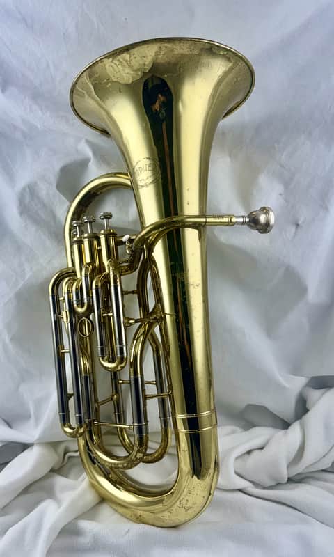 Gold brass trumpet, shiny, displayed on a wooden surface.