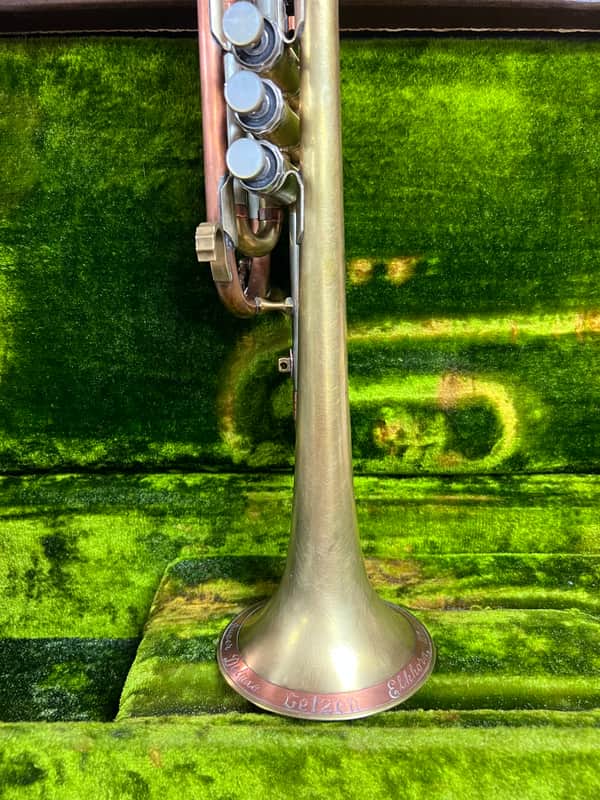 Brass trumpet with gold bell, silver valves, and orange/gold lacquer finish.