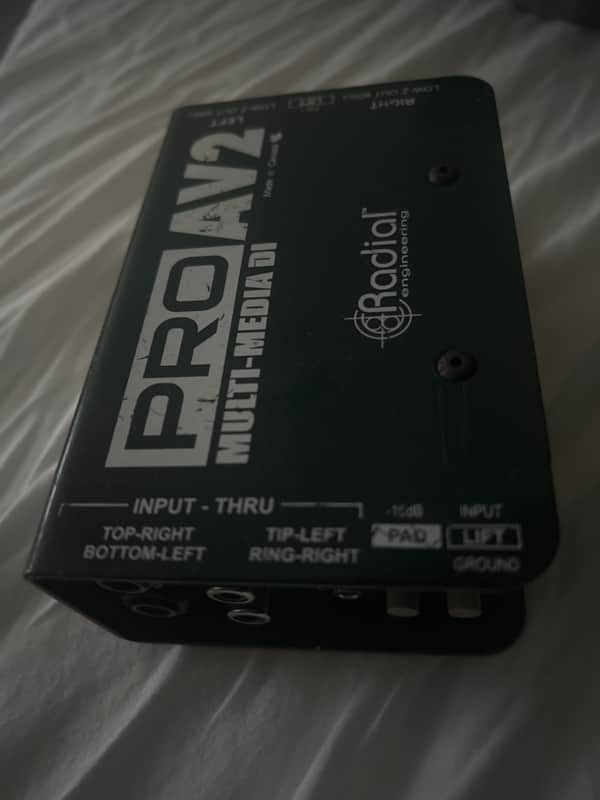 Black and silver stereo direct box with Radial branding and user guide.