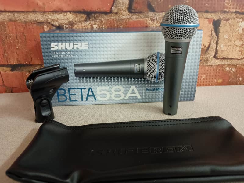 Silver microphone with blue grille, standing upright on black fabric.