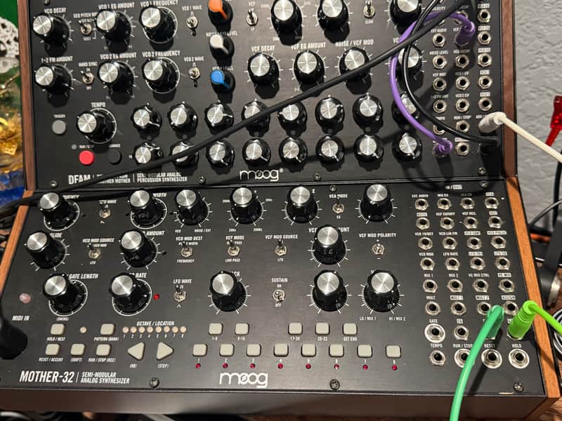 Black audio mixer board inside open cardboard box with cables.