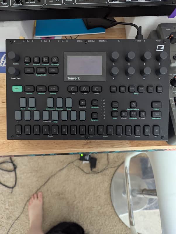 Black audio mixer with digital display showing settings and controls.