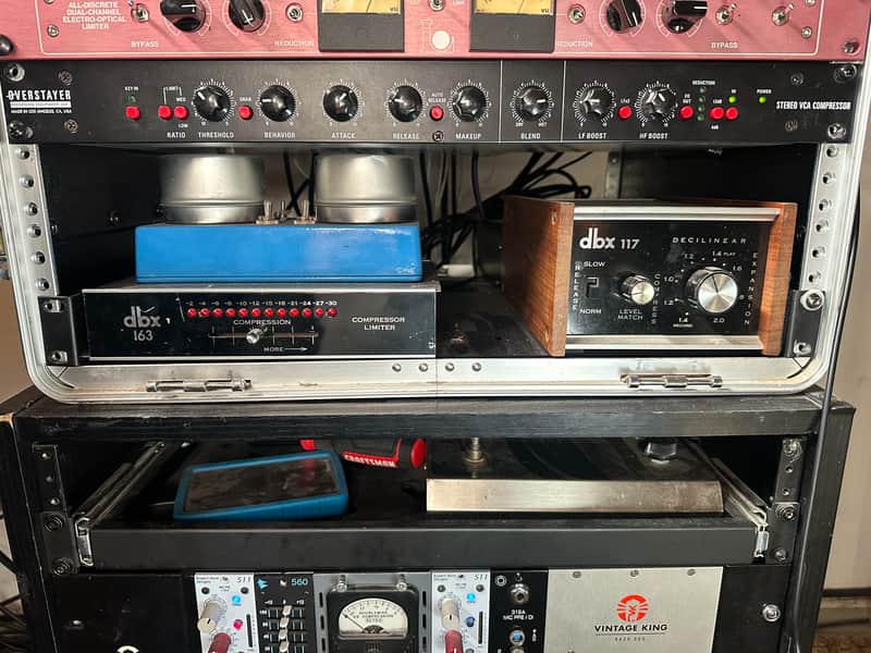 Red and black vintage audio rack with multiple knobs, meters, and digital displays.