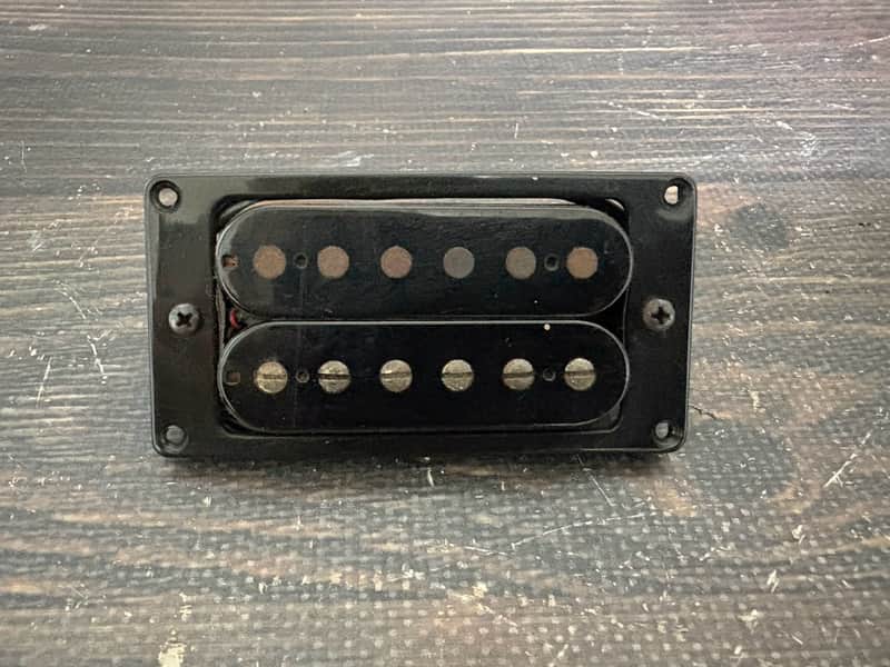 Black rectangular jackson guitar amplifier head on wooden surface.