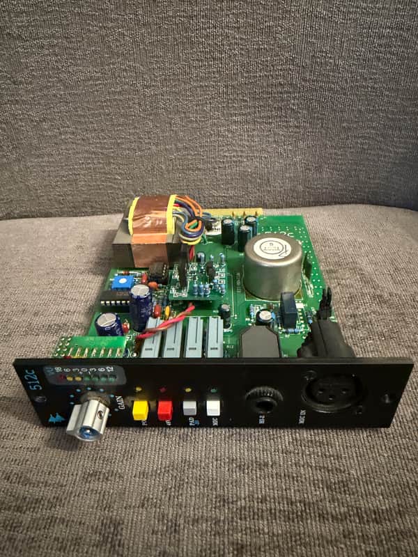 Black audio mixer with knobs, buttons, and input jacks visible.