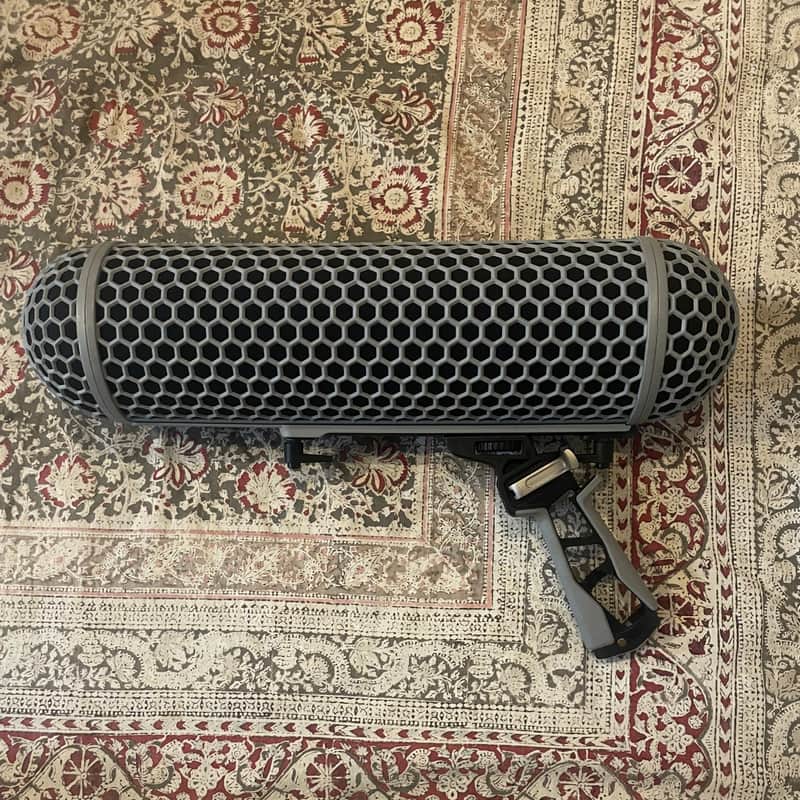 Black and white microphone with hexagonal mesh grille, resting on textured fabric.