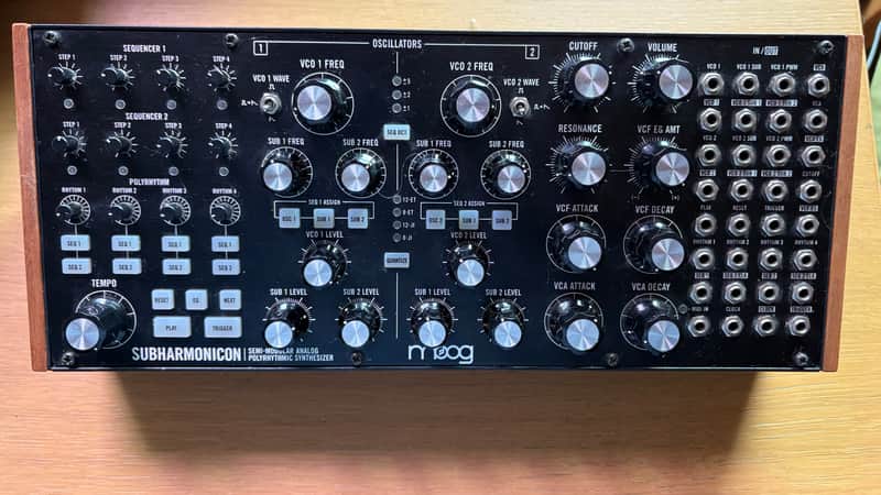Black synthesizer with numerous knobs, switches, and patch points.