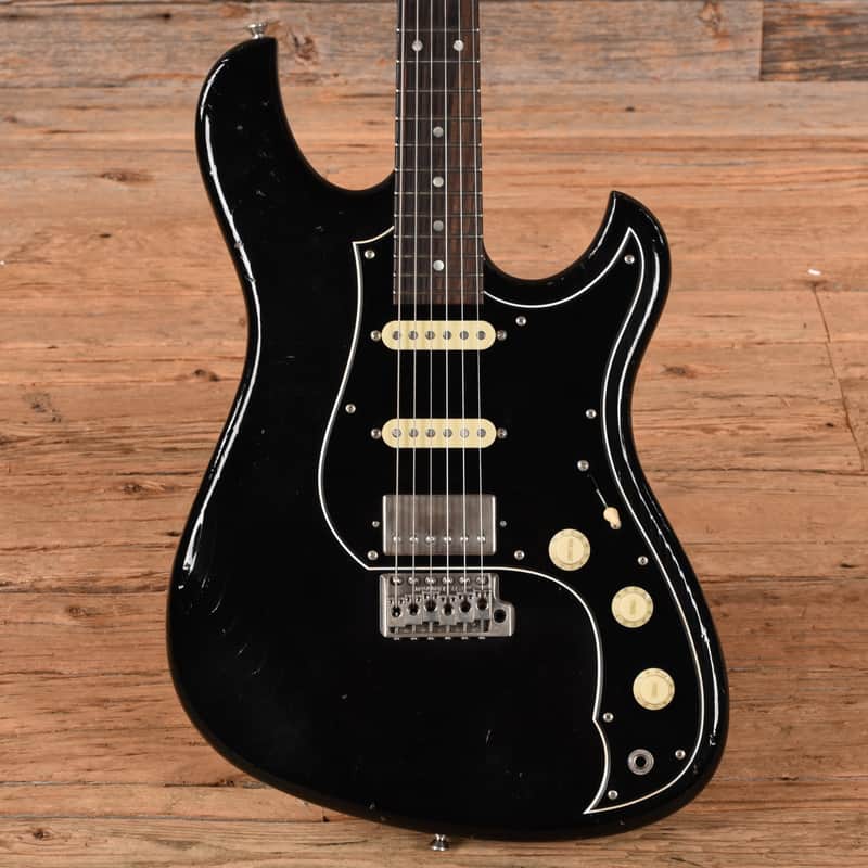 Black guitar case with red and white electric guitar inside.