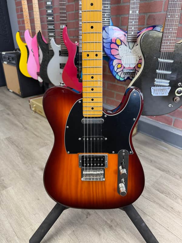 Black electric guitar in open black velvet-lined case.