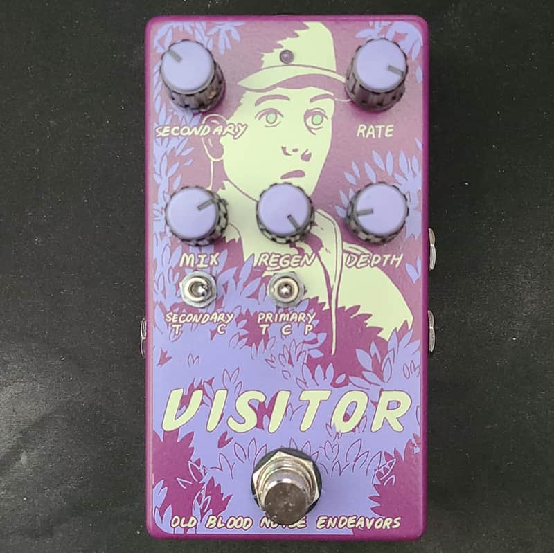 Purple guitar effects pedal with stylized face graphic and knobs.