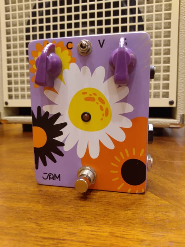 Purple and orange guitar effects pedal with sunflower design.